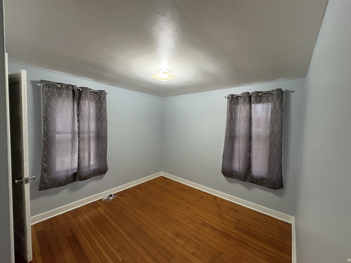 9758 East Flagg Road Rochelle, IL 61068 - Photo 12 of 22 an empty room with wooden floor and windows