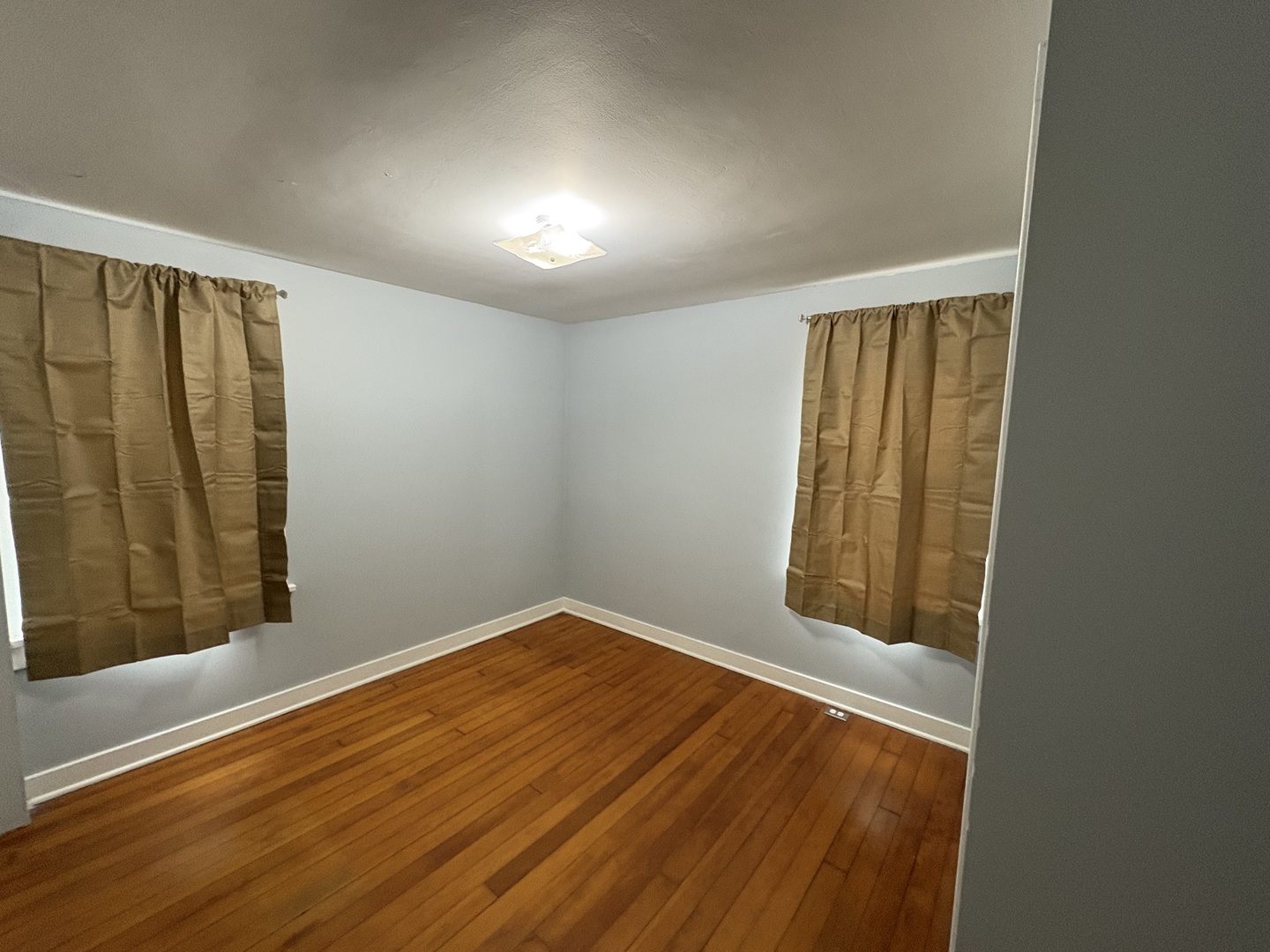 9758 East Flagg Road Rochelle, IL 61068 - Photo 14 of 22 an empty room with wooden floor and windows