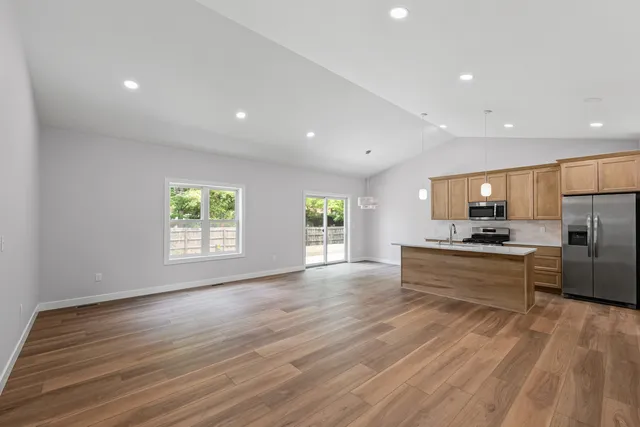 a kitchen with a sink a stove cabinets and wooden floor