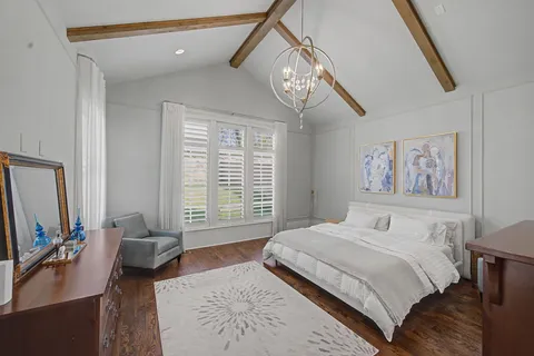 a bedroom with a large bed and a chandelier