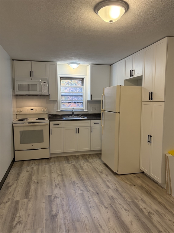 a kitchen with wooden cabinets and white appliances