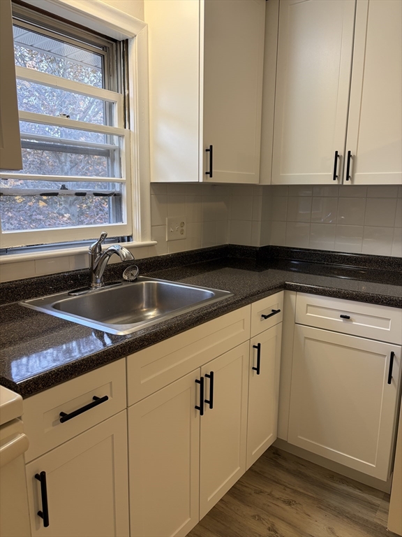 109 Trapelo Road, Unit 4 Waltham, MA 02452 - Photo 3 of 13 a kitchen with granite countertop white cabinets white appliances and a sink