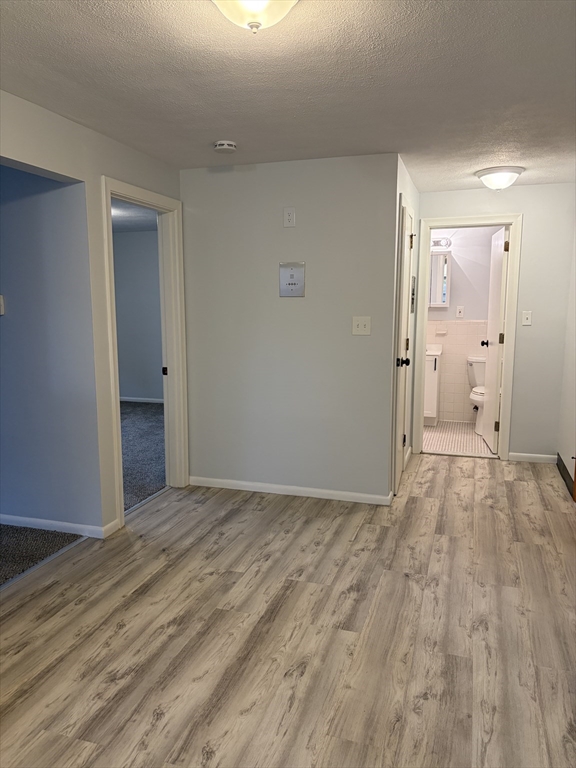 109 Trapelo Road, Unit 4 Waltham, MA 02452 - Photo 4 of 13 a view of an empty room and wooden floor