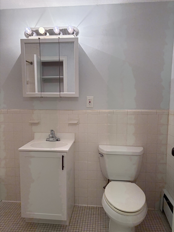 109 Trapelo Road, Unit 4 Waltham, MA 02452 - Photo 5 of 13 a bathroom with a toilet a sink and mirror