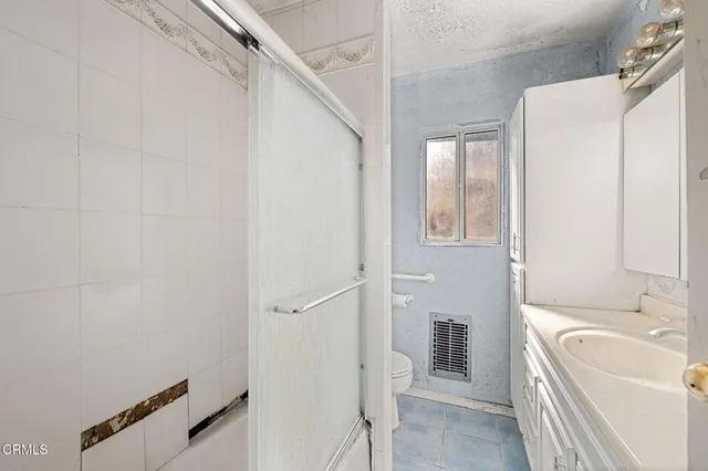 a bathroom with a sink a toilet and shower