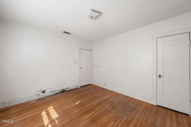 a view of a room with wooden floor and white walls
