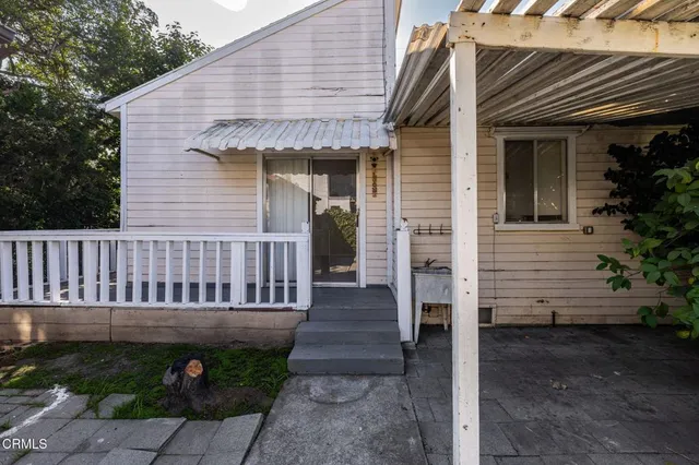 a view of a house with wooden deck and furniture