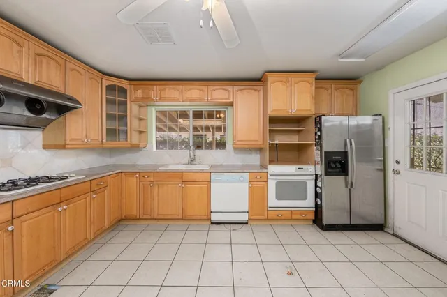 a kitchen with stainless steel appliances granite countertop a refrigerator and a stove top oven