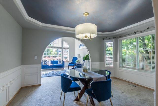 a kitchen with stainless steel appliances granite countertop a refrigerator a sink a stove a washer dryer and a refrigerator