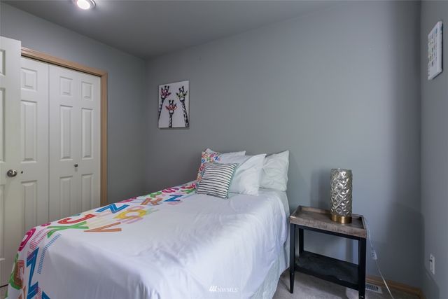 a bedroom with a bed and a large window