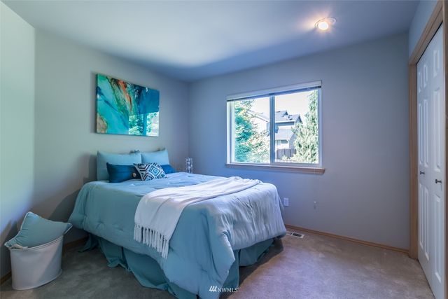 a view of a backyard with table and chairs potted plants and large tree