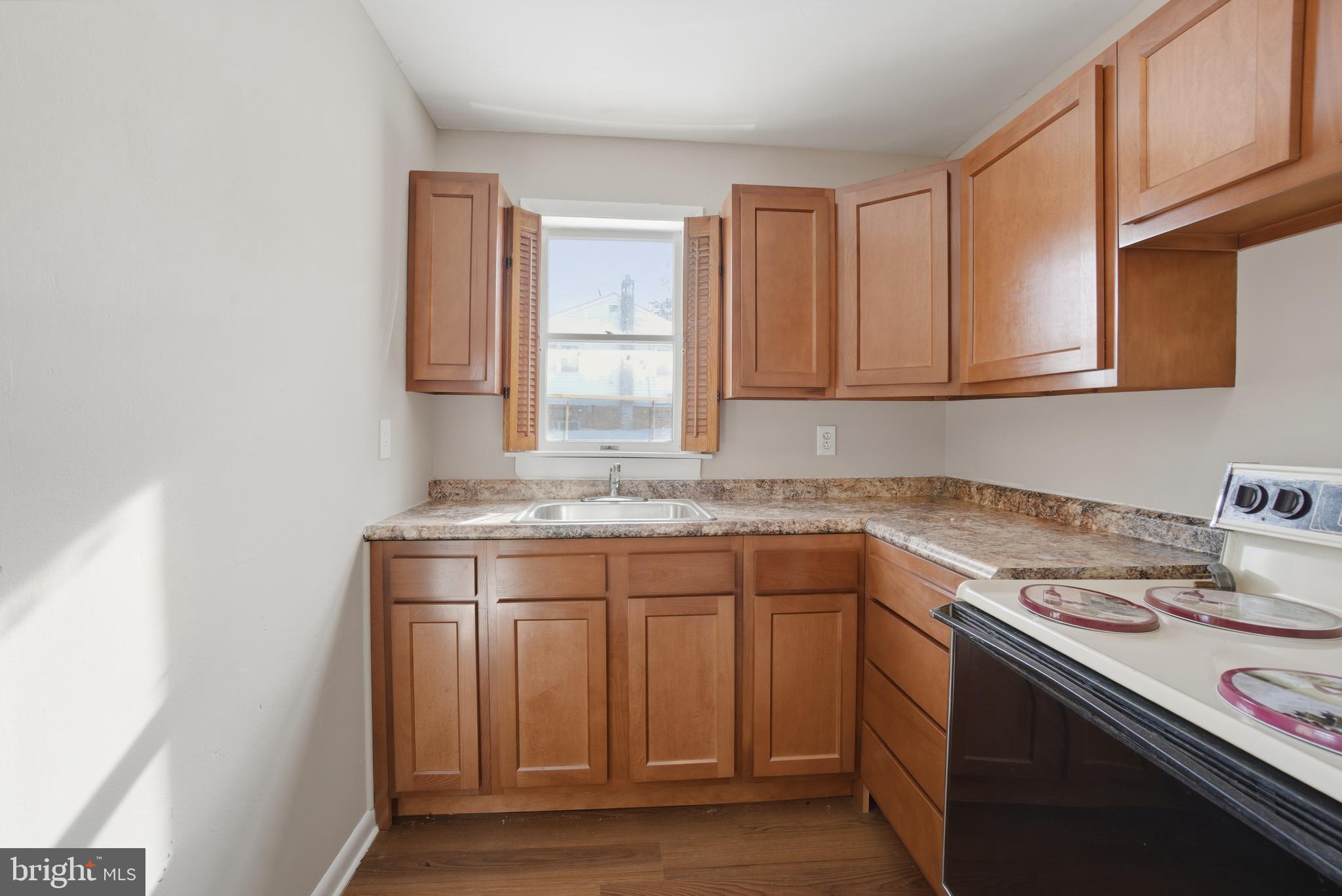 5605 Shelbourne Road, Unit B Baltimore, MD 21227 - Photo 10 of 20 a kitchen with stainless steel appliances granite countertop a sink stove and cabinets