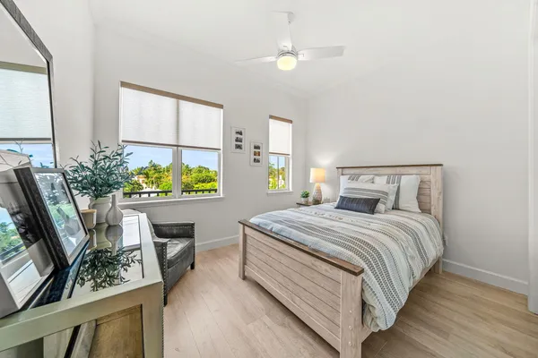 a bedroom with a bed potted plant on the dresser and a window