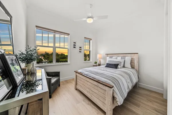 a bedroom with a bed a dresser next to a window