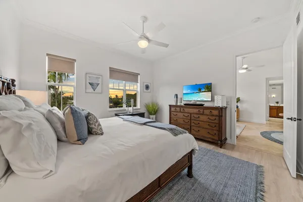 a spacious bedroom with a bed a couch and a chandelier