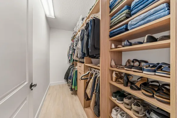 a view of walk in closet with clothes and shoes