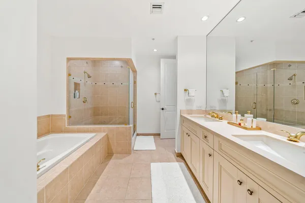 a spacious bathroom with a tub sink shower and mirror