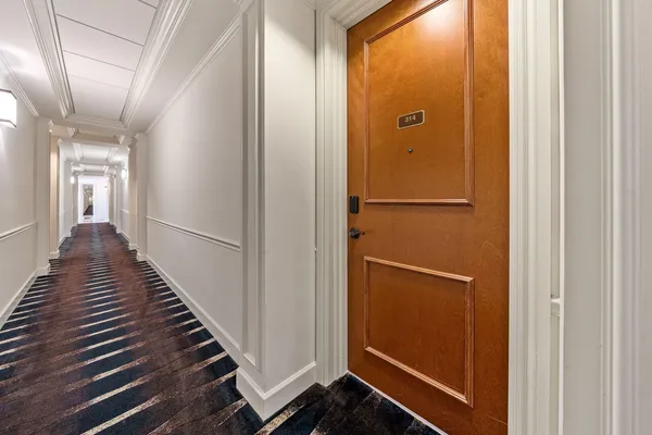 a view of a hallway with wooden floor