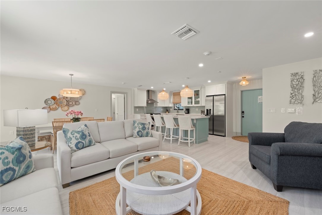 a living room with furniture and a view of kitchen