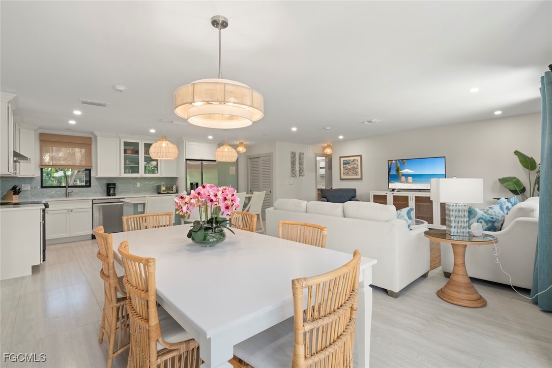 5117 Sea Bell Road, Unit G102 Sanibel, FL 33957 - Photo 12 of 49 a view of a dining room and livingroom with furniture wooden floor a chandelier