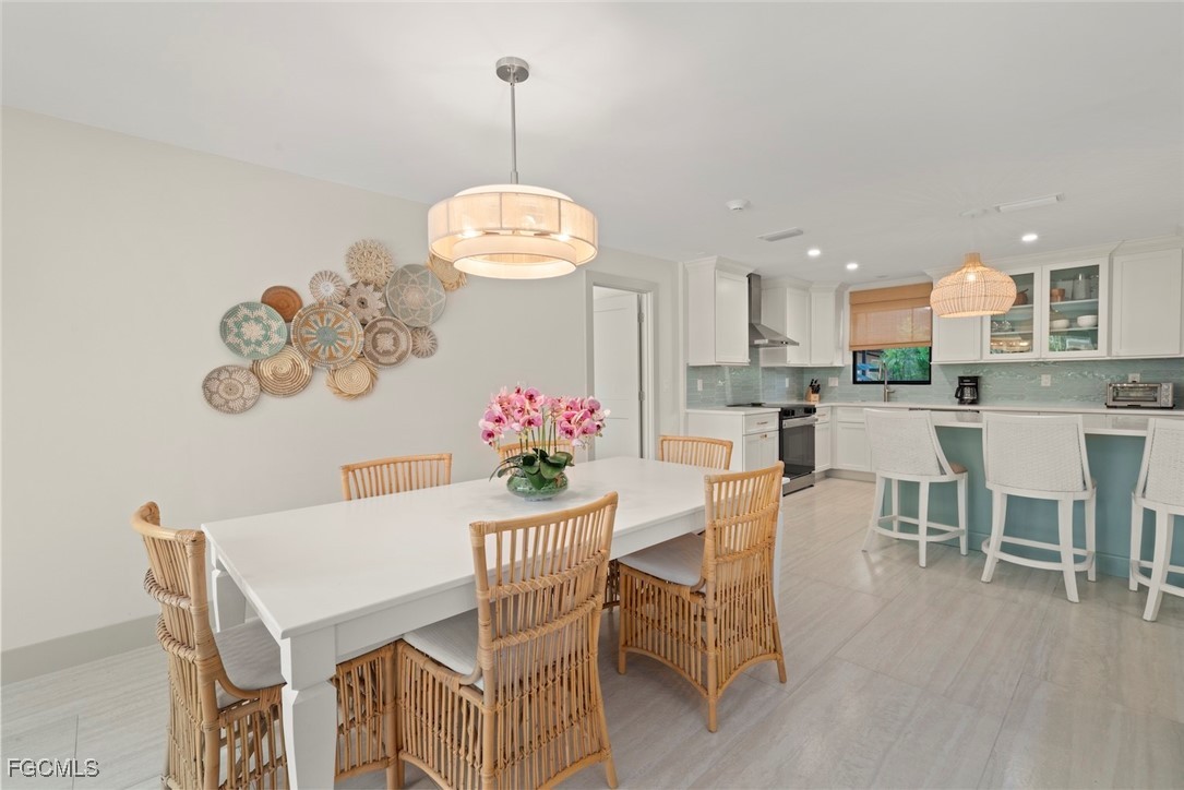 5117 Sea Bell Road, Unit G102 Sanibel, FL 33957 - Photo 13 of 49 a view of a dining room with furniture wooden floor and chandelier