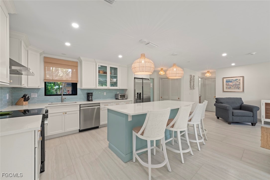 5117 Sea Bell Road, Unit G102 Sanibel, FL 33957 - Photo 14 of 49 a kitchen with a dining table chairs and white cabinets