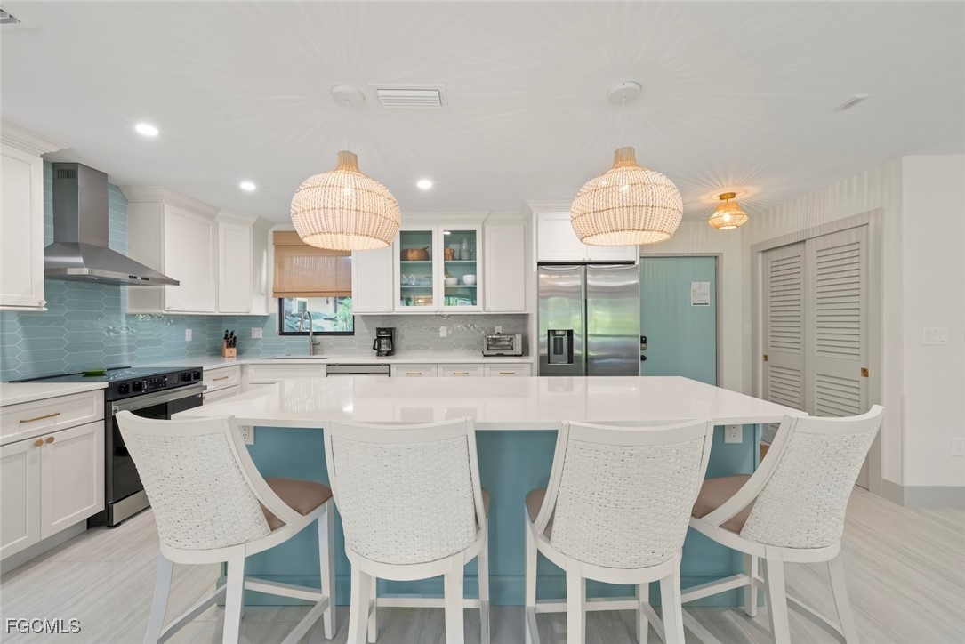 5117 Sea Bell Road, Unit G102 Sanibel, FL 33957 - Photo 15 of 49 a kitchen with stainless steel appliances granite countertop a table chairs and a white cabinets