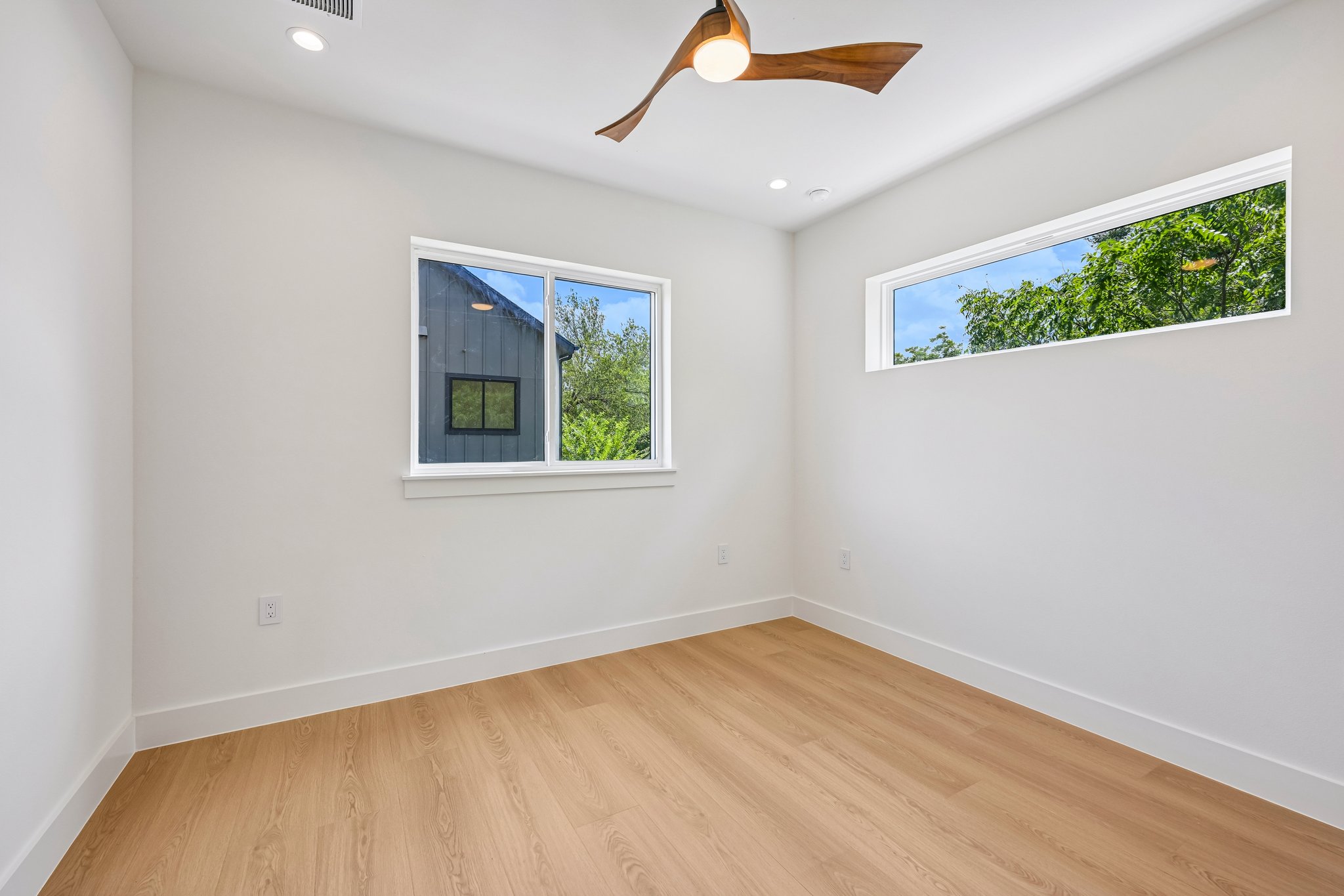 513 West Odell Street, Unit B Austin, TX 78752 - Photo 31 of 38 Blonde wood look flooring and multiple windows enhance this bright, airy room.