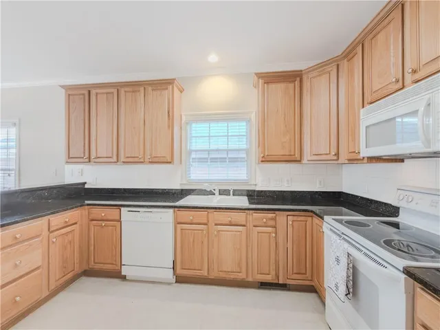 a kitchen with white cabinets sink and dishwasher
