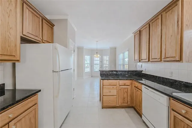 a kitchen with granite countertop a sink stove and cabinets