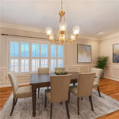 a view of a dining room with furniture a chandelier and wooden floor