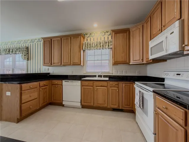 a kitchen with granite countertop cabinets stainless steel appliances and a sink