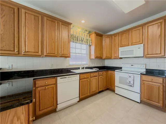 a kitchen with granite countertop white cabinets sink and dishwasher