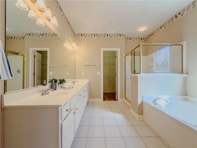 a spacious bathroom with a bathtub sink and mirror