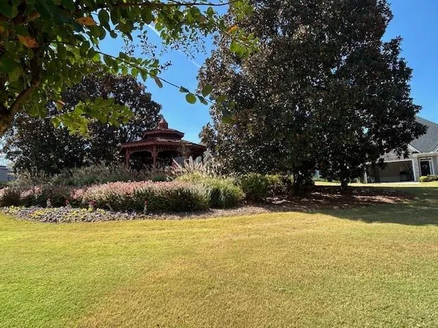 a front view of a house with a yard and swimming pool