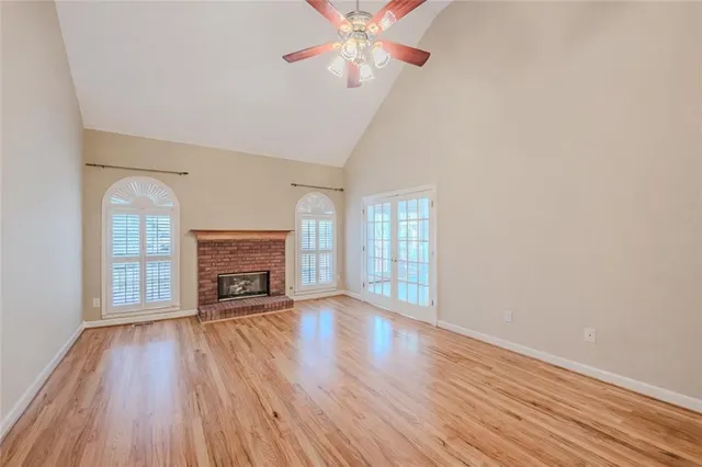 wooden floor fireplace and windows in an empty room
