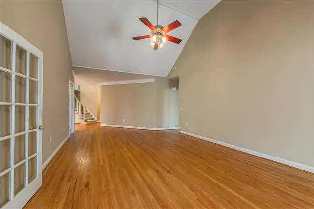 an empty room with wooden floor fireplace and windows