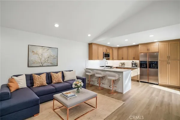 a living room with stainless steel appliances kitchen island granite countertop furniture and a view of kitchen
