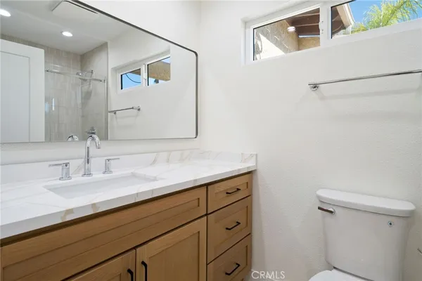 a bathroom with a sink a toilet and mirror