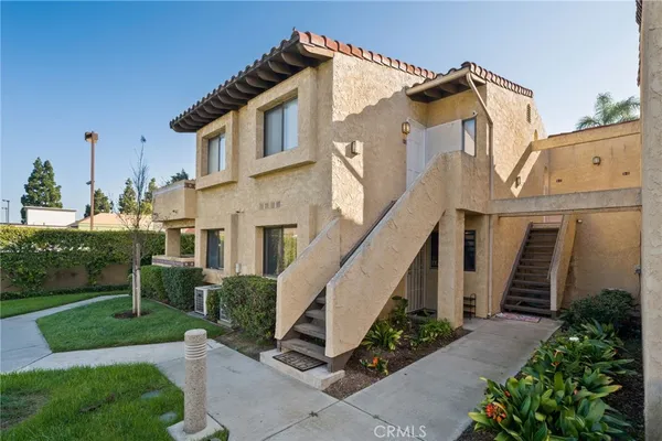 a view of a white house next to a yard