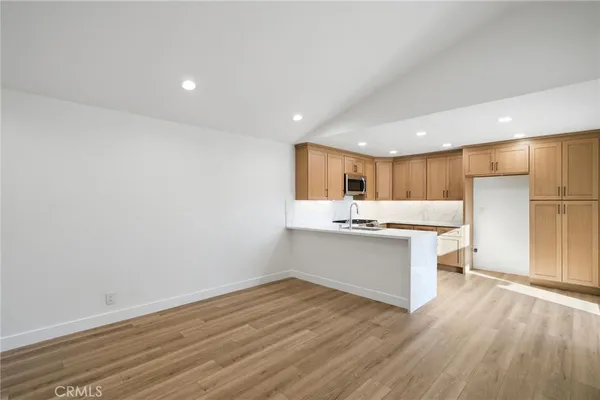a kitchen with a sink cabinets and wooden floor
