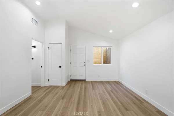 a view of a room with wooden floor and white doors