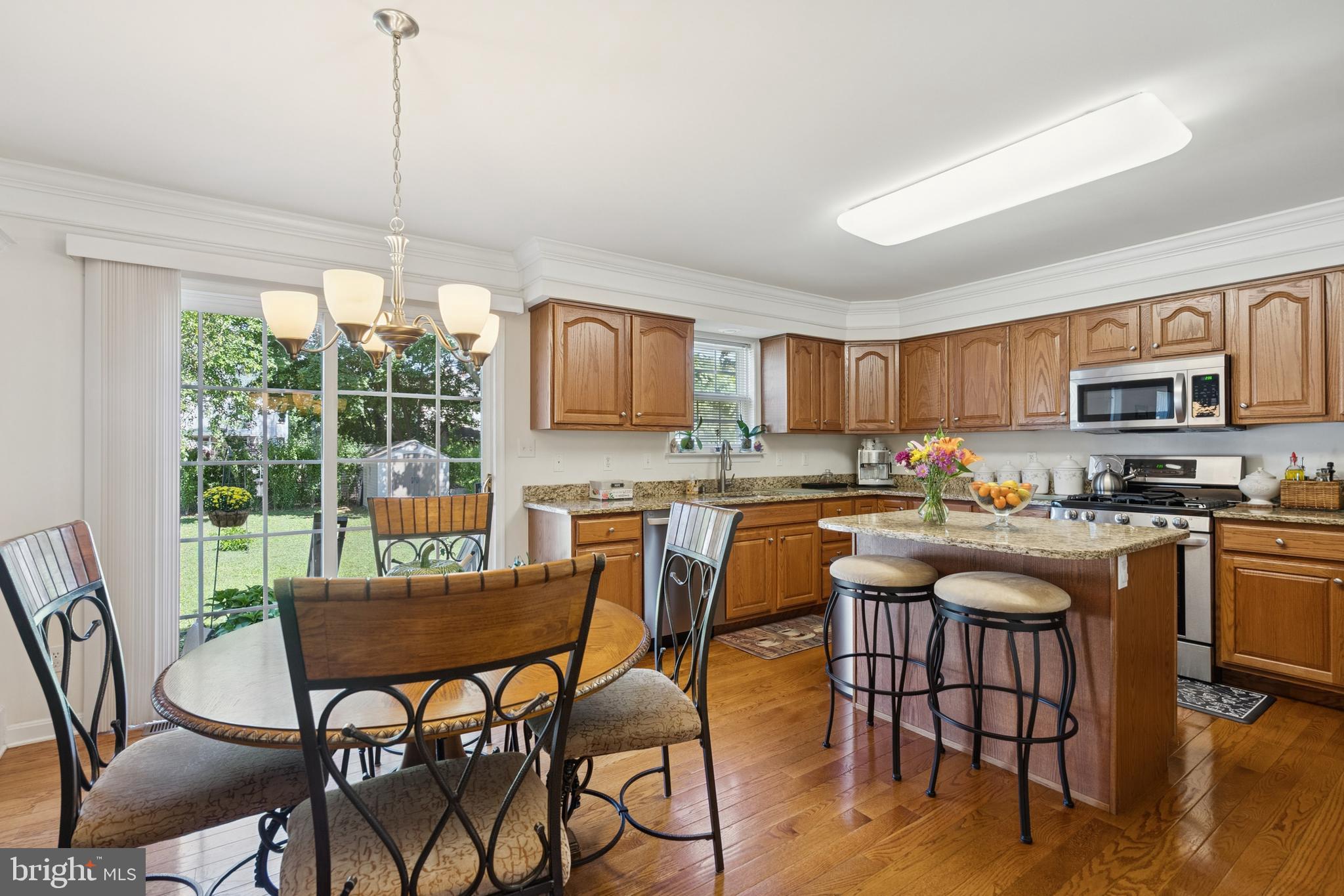 217 Cleveland Avenue Riverside, NJ 08075 - Photo 7 of 25 a kitchen with granite countertop a table chairs microwave and cabinets