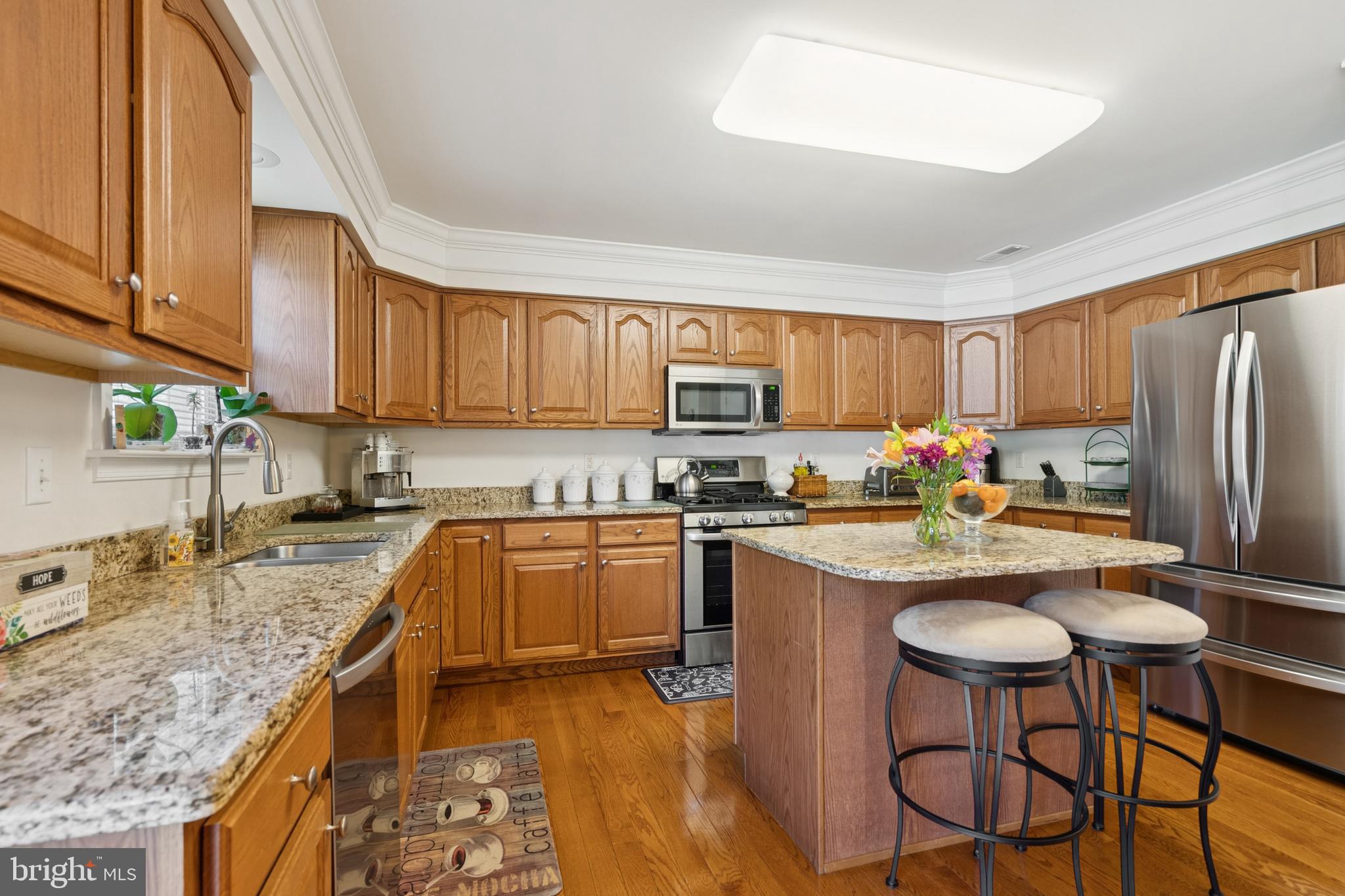 217 Cleveland Avenue Riverside, NJ 08075 - Photo 8 of 25 a kitchen with stainless steel appliances granite countertop a stove top oven a sink dishwasher a stove and a refrigerator with wooden cabinets