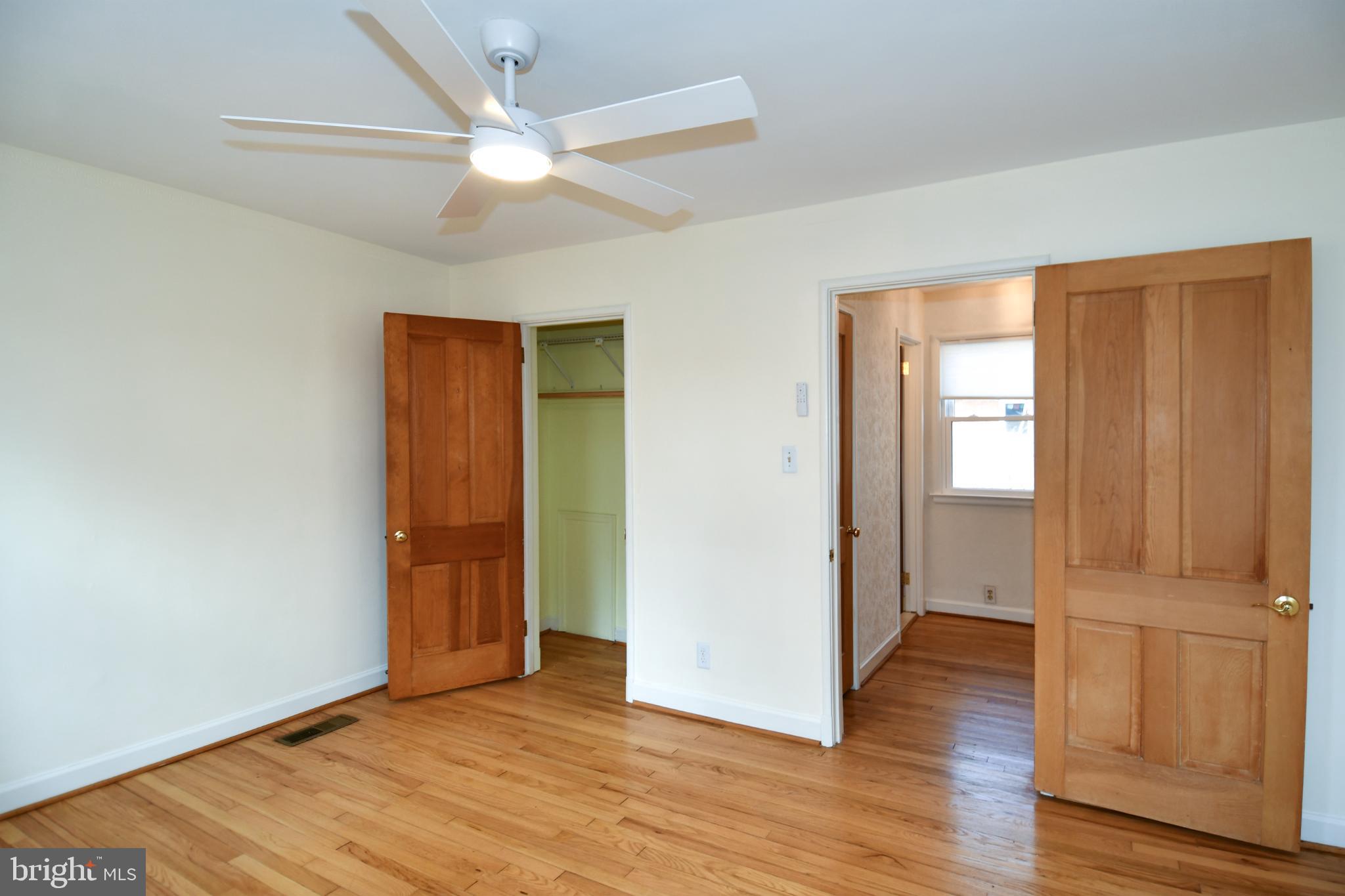 8520 Geren Road, Unit 183 Silver Spring, MD 20901 - Photo 26 of 34 an empty room with wooden floor fan and windows