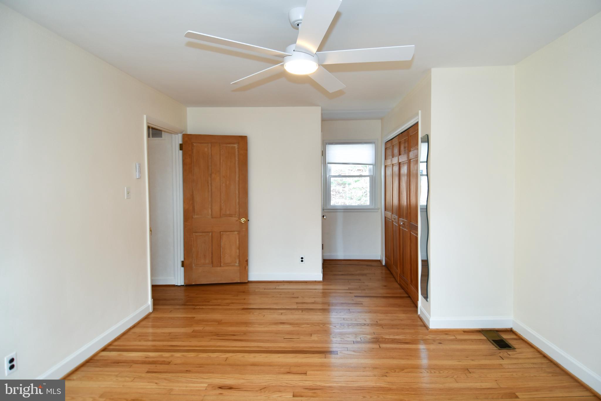 8520 Geren Road, Unit 183 Silver Spring, MD 20901 - Photo 29 of 34 an empty room with wooden floor and windows
