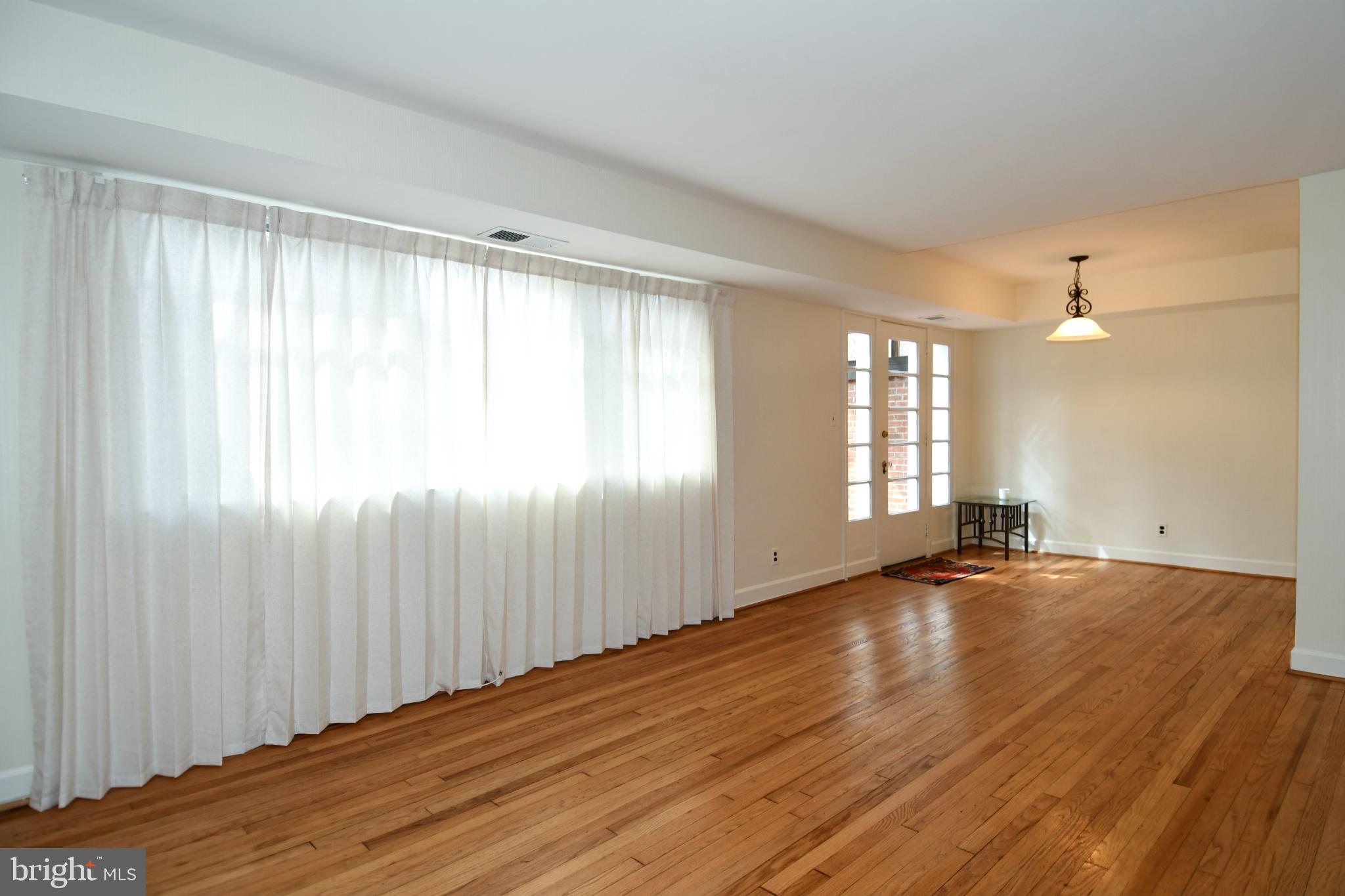 8520 Geren Road, Unit 183 Silver Spring, MD 20901 - Photo 9 of 34 an empty room with wooden floor and windows