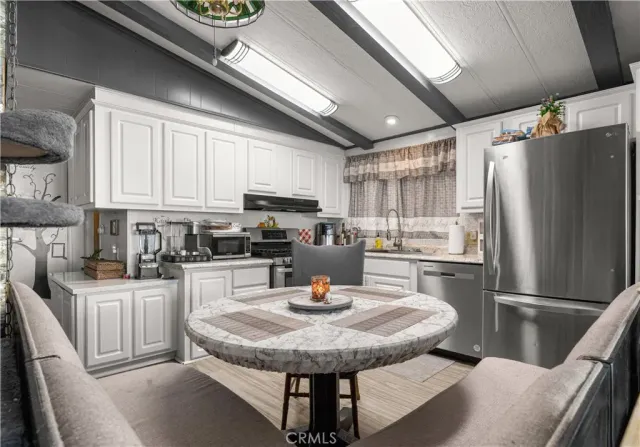 a kitchen with a table chairs and refrigerator