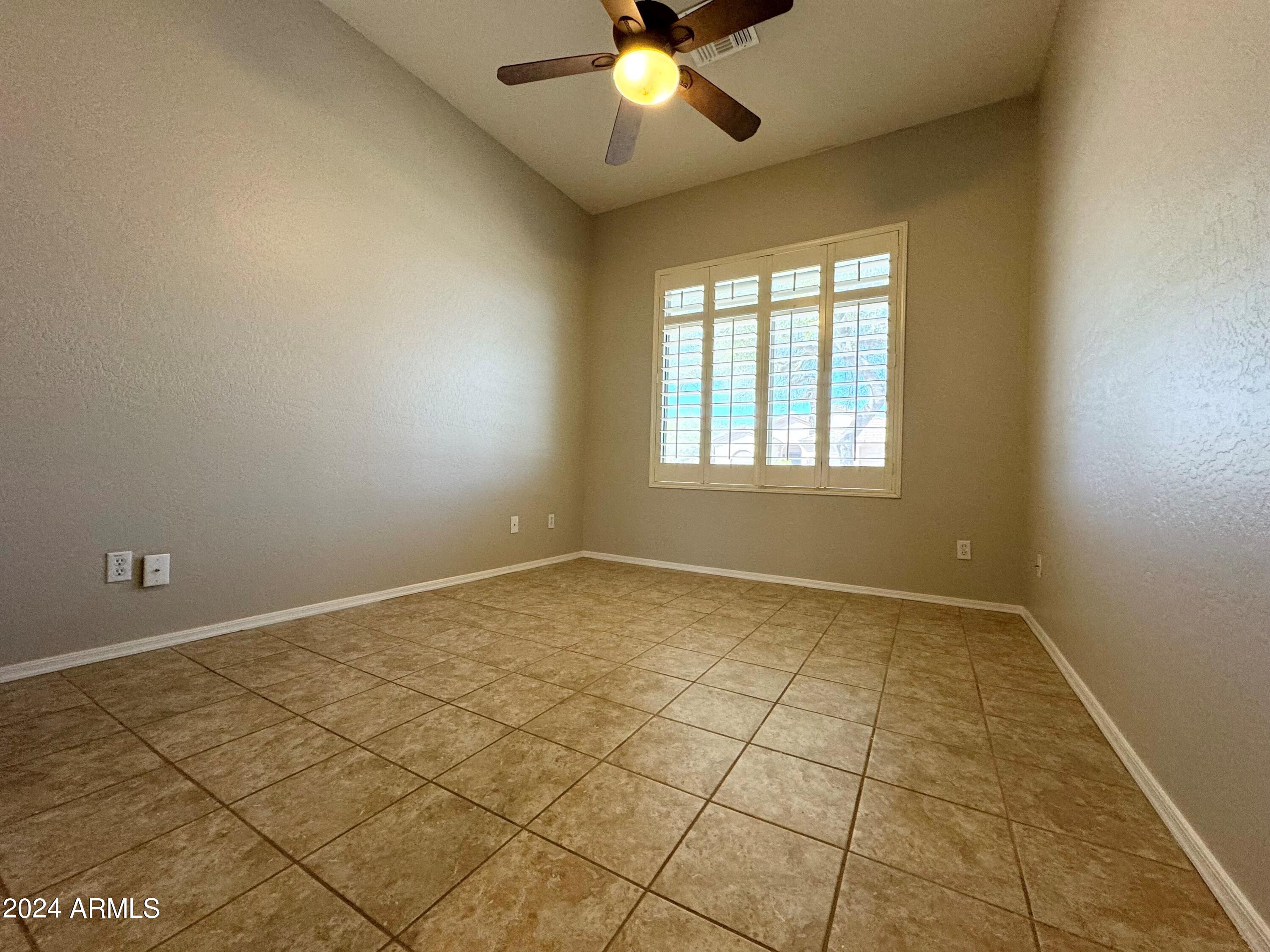 18426 West Piedmont Road Goodyear, AZ 85338 - Photo 17 of 25 an empty room with windows and ceiling fan