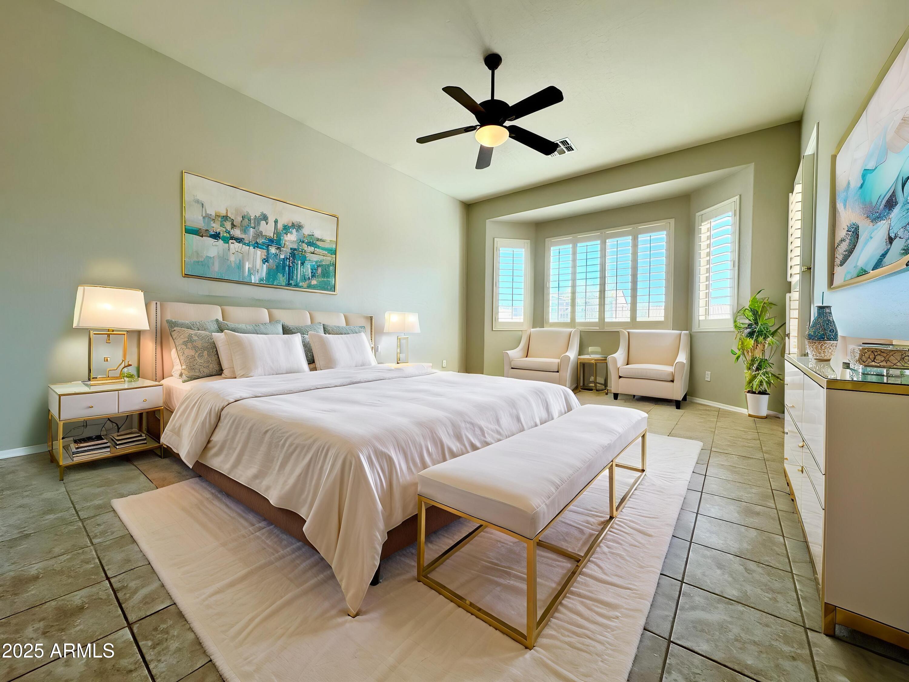 18426 West Piedmont Road Goodyear, AZ 85338 - Photo 18 of 25 a spacious bedroom with a bed a couch and a window